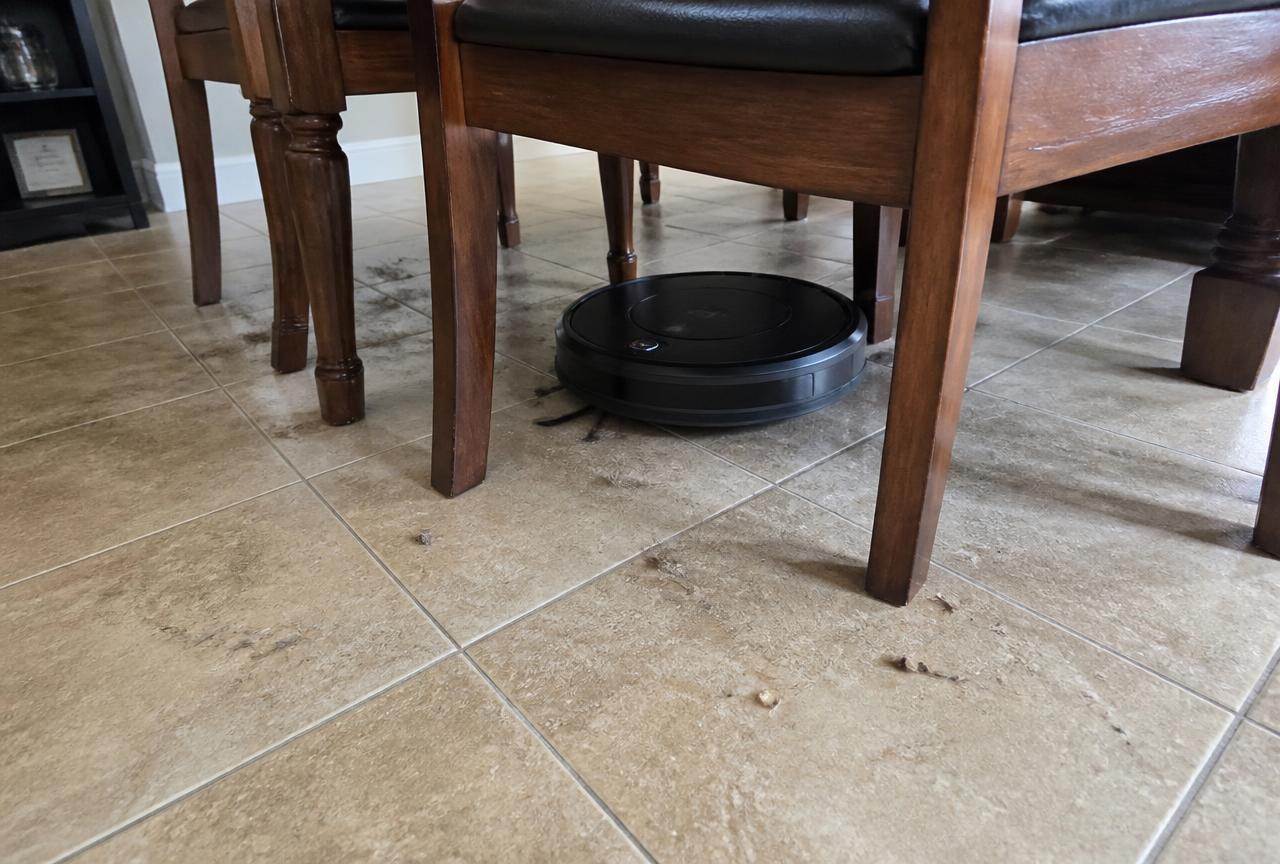 Il robot aspirapolvere passa tra le gambe delle sedie sotto il tavolo da pranzo